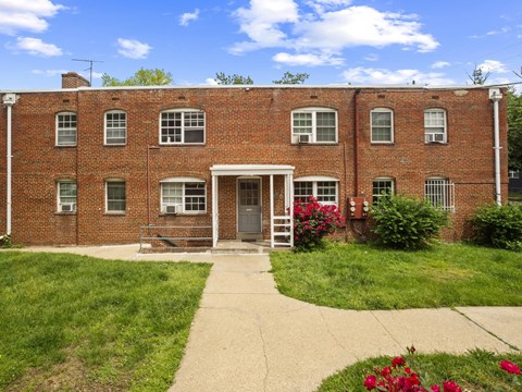 A red brick building with a white door and windows.