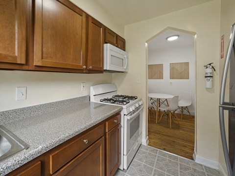 A kitchen with a white stove and wooden cabinets.