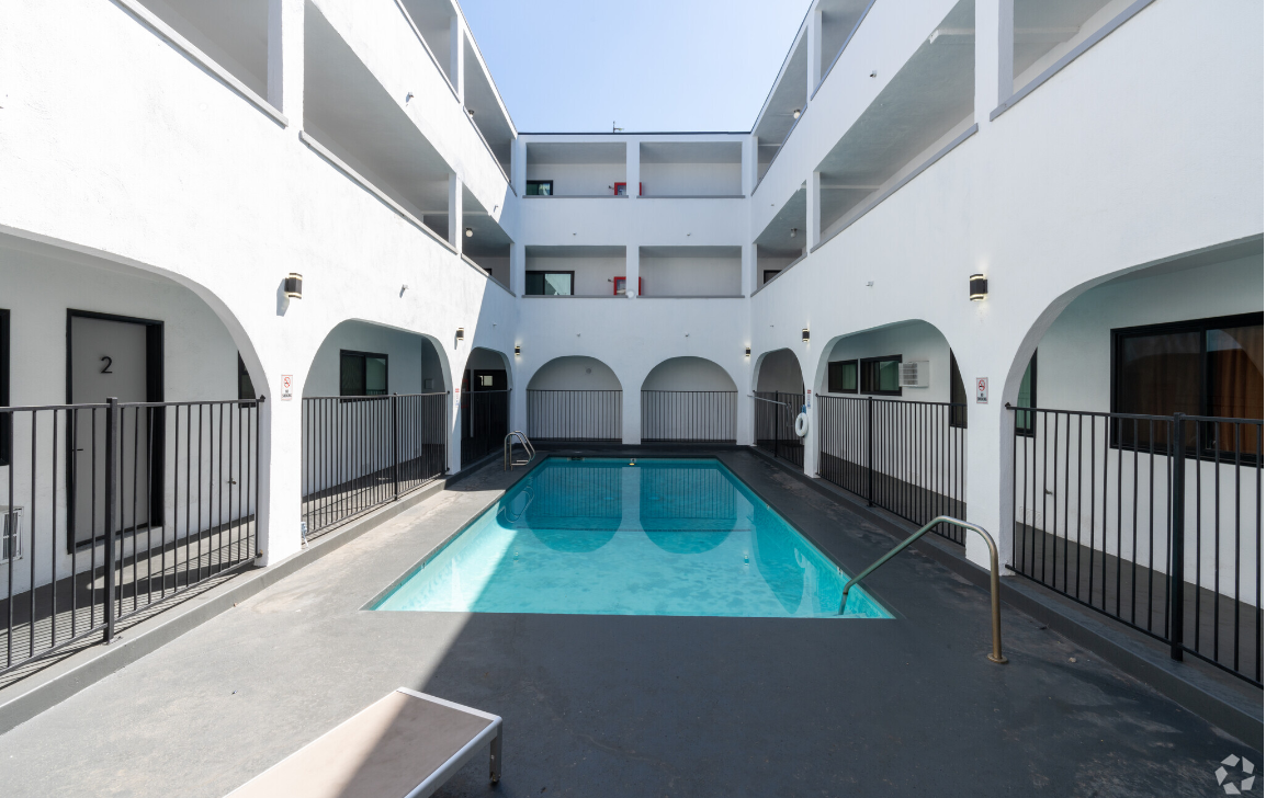A small pool in a courtyard surrounded by buildings.
