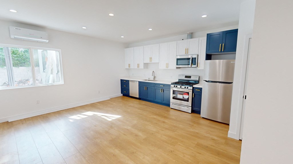 an empty kitchen with blue cabinets and stainless steel appliances