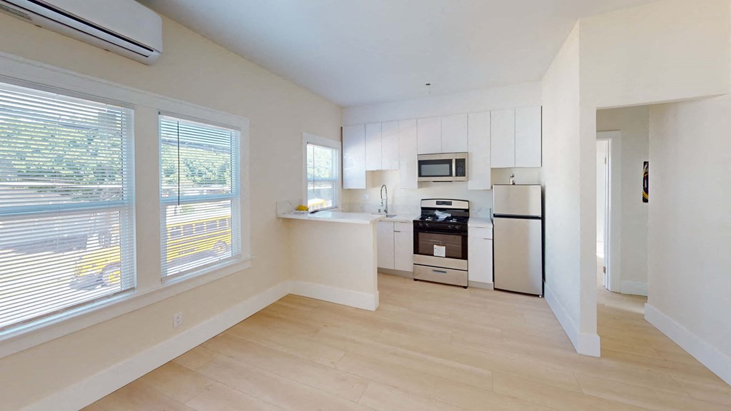 a kitchen with white cabinets and a large window