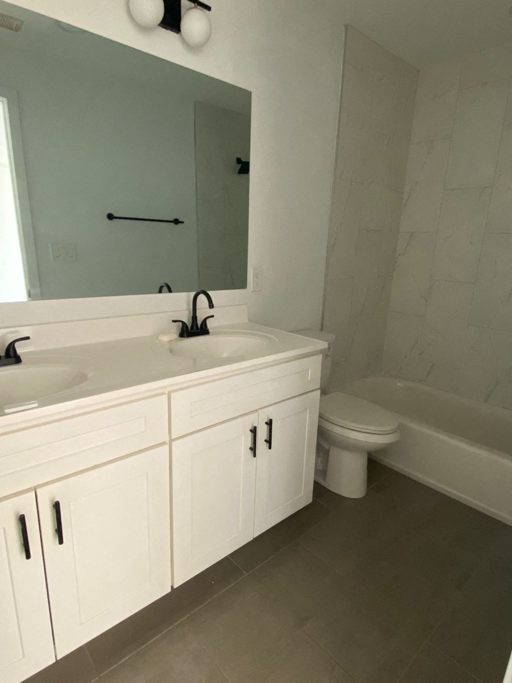 A white bathroom with a sink, toilet, and bathtub.