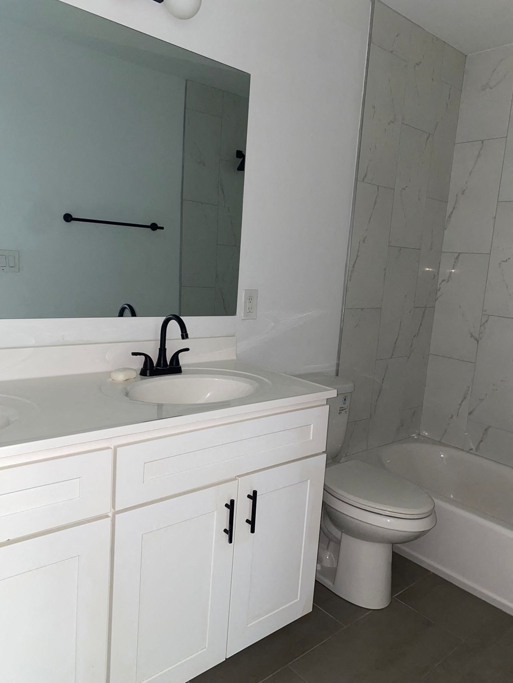 A white bathroom with a sink, toilet and bathtub.