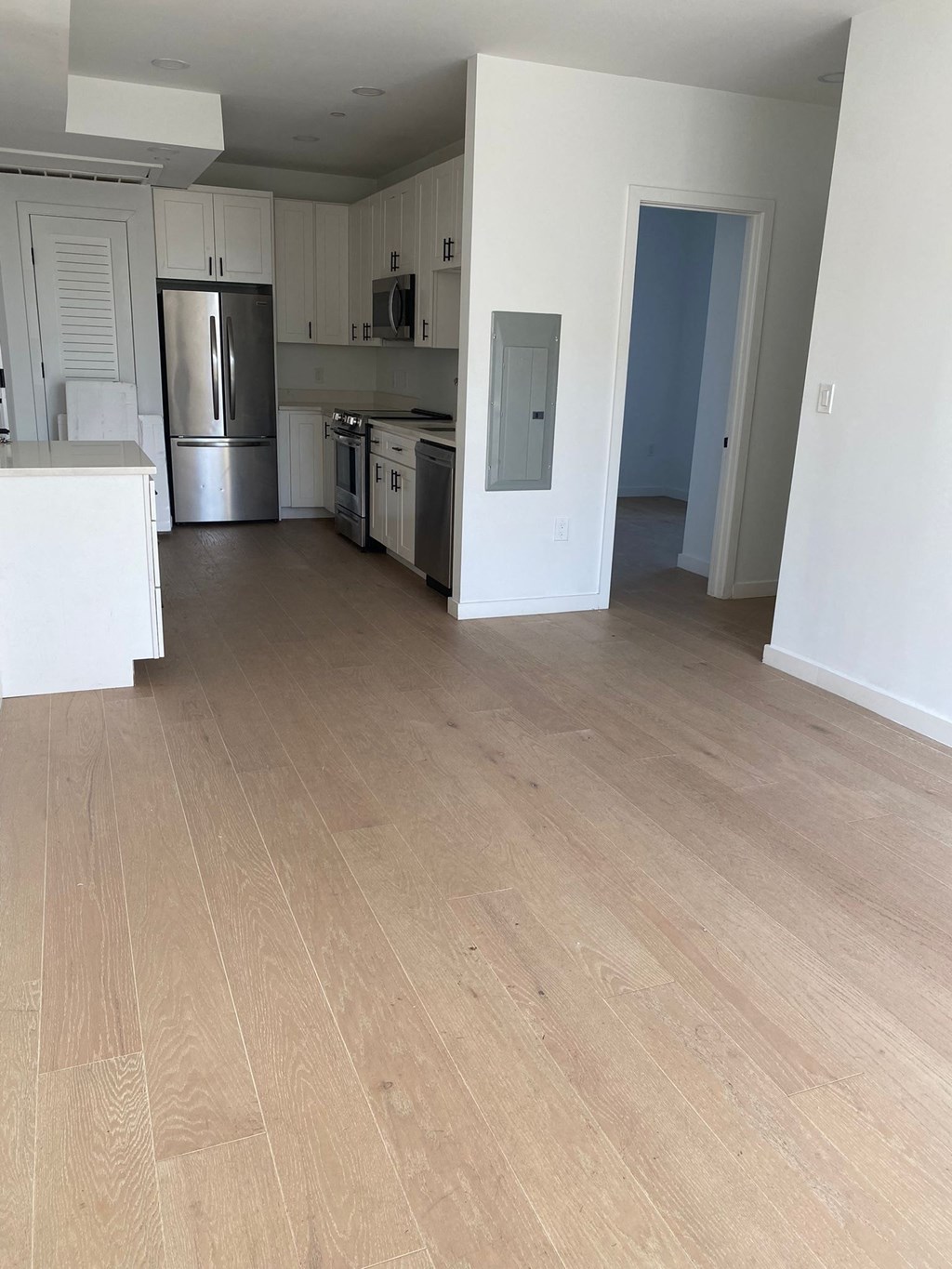 A kitchen with white cabinets and a refrigerator.