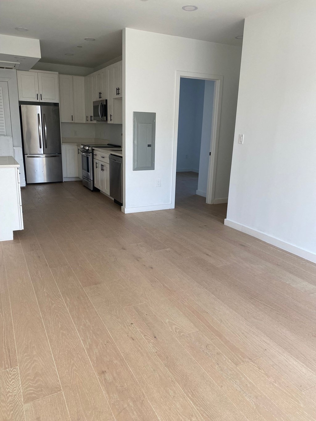 A kitchen with white cabinets and a refrigerator.