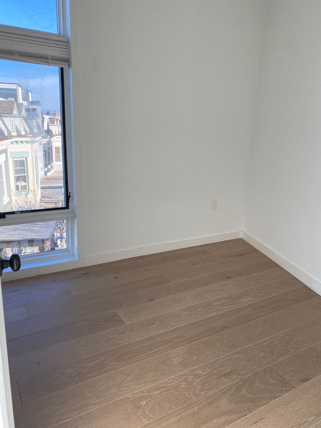 A room with a window overlooking a street.