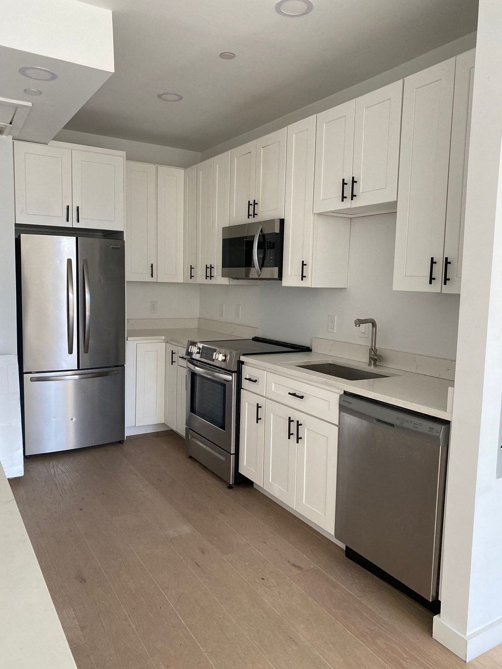 A kitchen with white cabinets and stainless steel appliances.