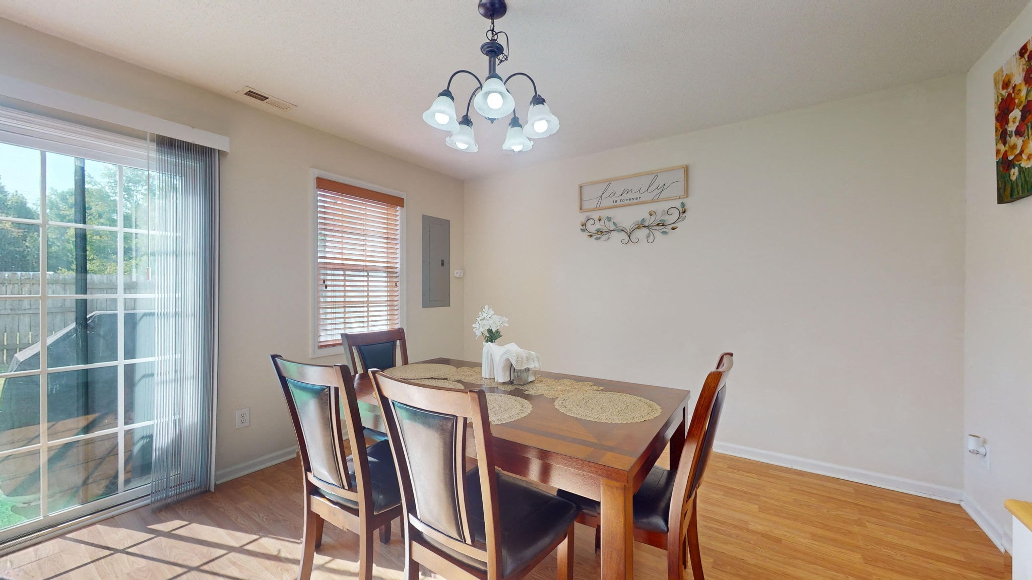 a dining room with a table and chairs and a sliding glass door