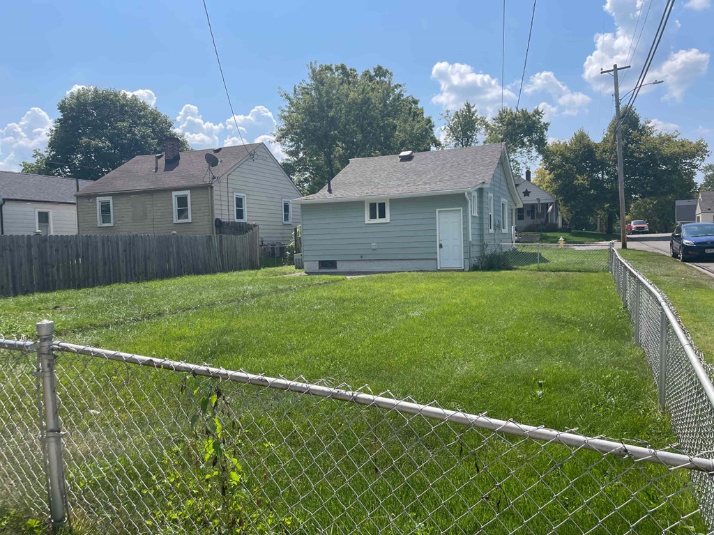 a backyard with a fence and two houses