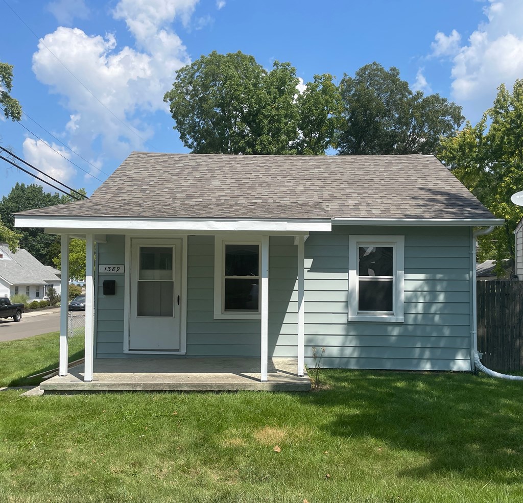 the front of a blue house with a porch