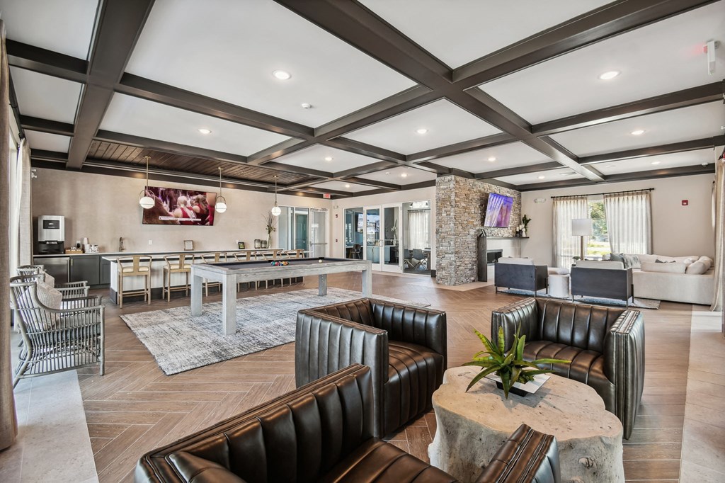 a clubhouse with a pool table and chairs and a bar