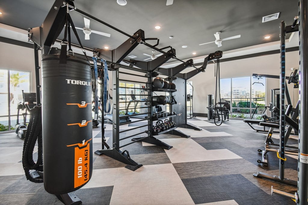 a gym with weights and a punching bag in the center