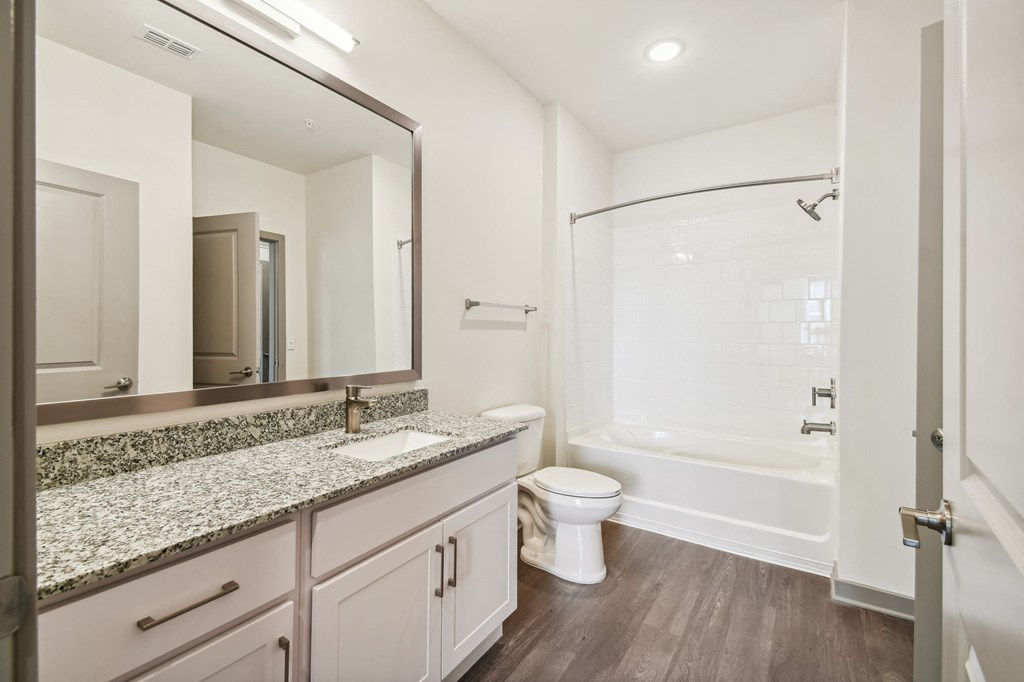 a bathroom with a large mirror and a toilet and a shower