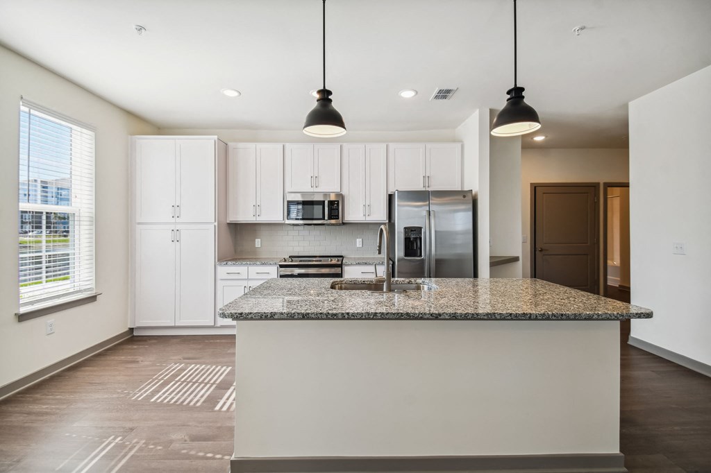 a kitchen with white cabinets and a granite counter top