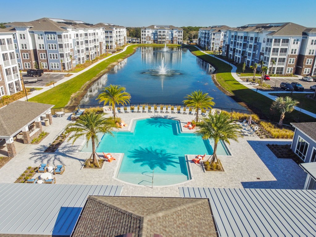 an aerial view of a large swimming pool with palm trees