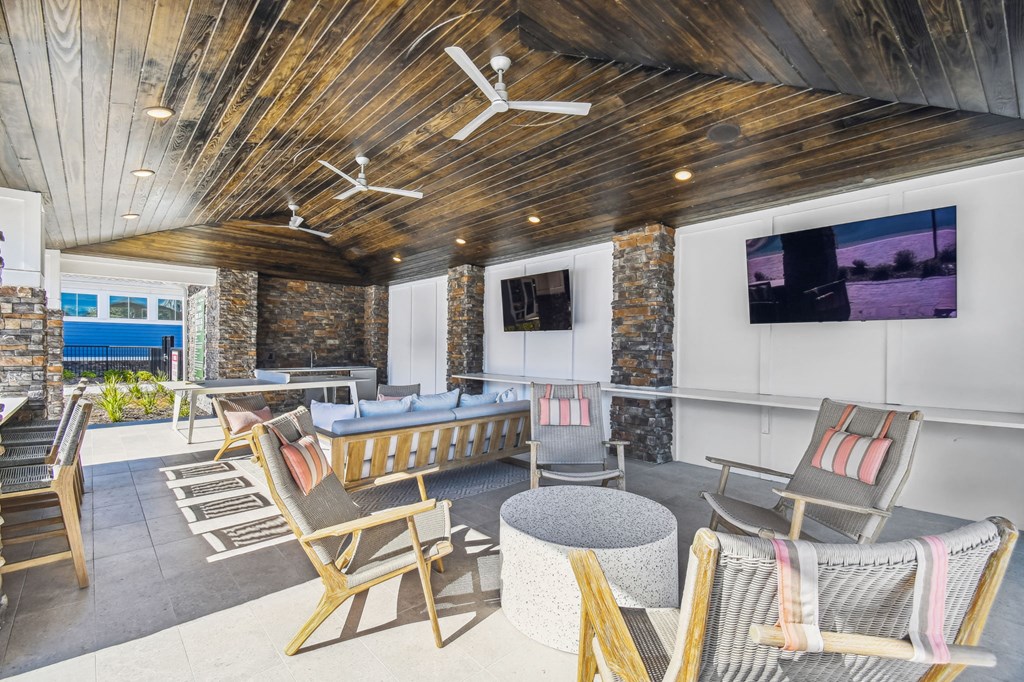 a lounge area with chairs and tables and a television