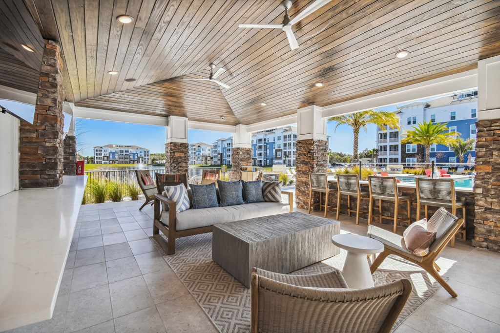 a covered patio with furniture and a view of the ocean