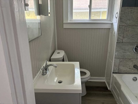 A white bathroom with a toilet, sink, and bathtub.