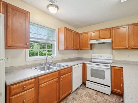 A kitchen with wooden cabinets and white appliances.