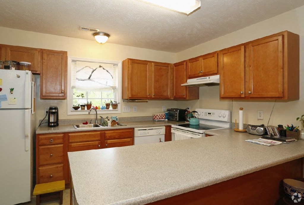 A kitchen with wooden cabinets and a white refrigerator.