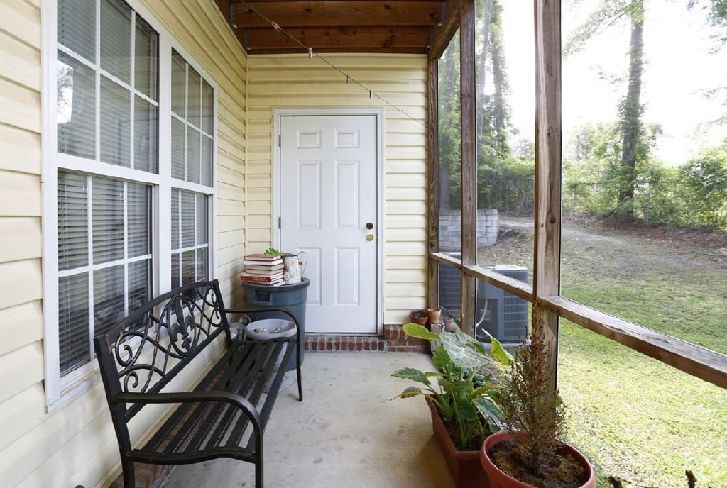 A small porch with a bench and a door.