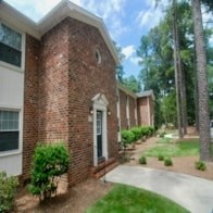 A brick house with a white door and a window.