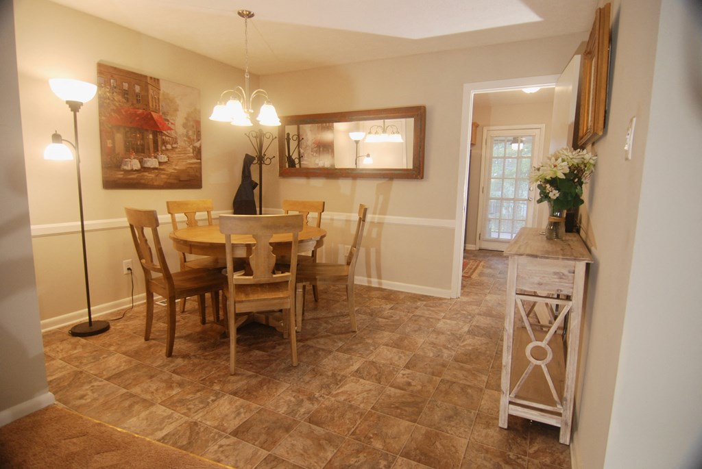 A dining room with a table and chairs.