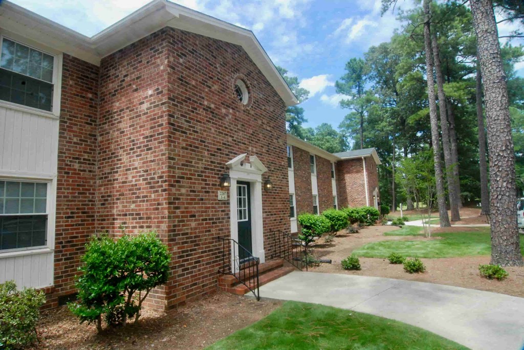 A brick house with a white door and a small window.