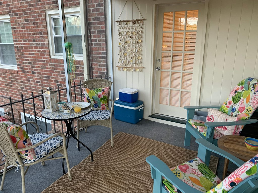 A small balcony with a table and chairs.
