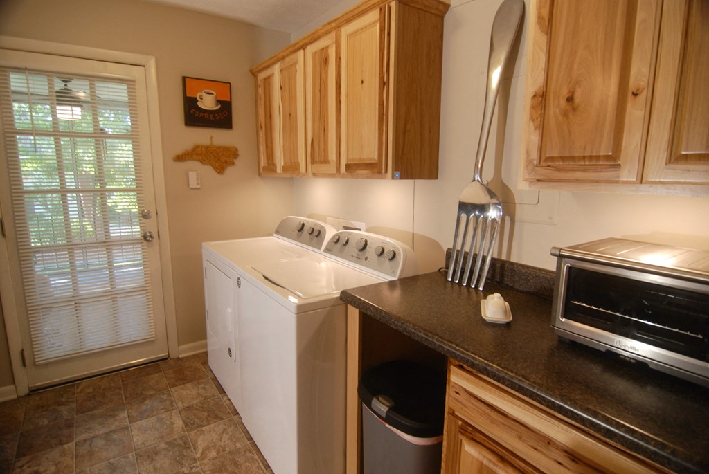 A kitchen with a white dishwasher and wooden cabinets.