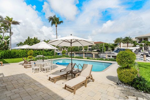a swimming pool with chairs and umbrellas at a resort