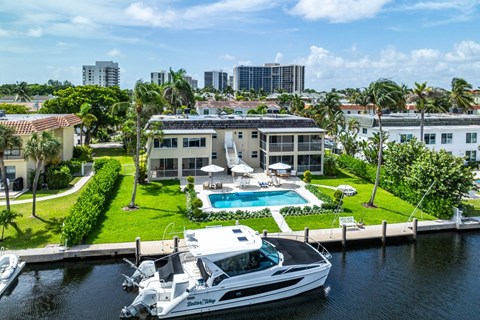 a yacht is docked in front of a house with a pool