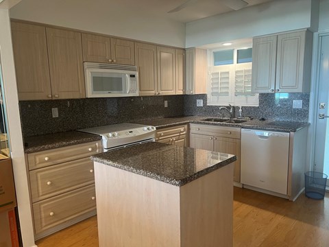 a kitchen with white cabinets and granite counter tops