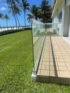 a glass railing on a patio next to a lawn and a house