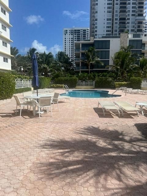 a pool with chairs and an umbrella next to a building