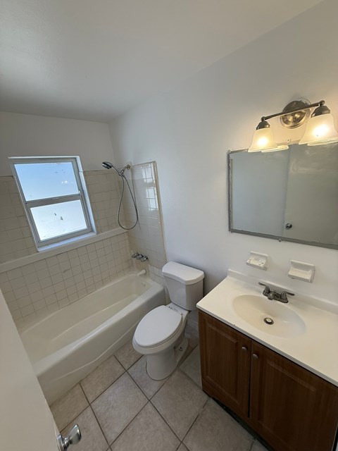 A bathroom with a toilet, sink, and bathtub.