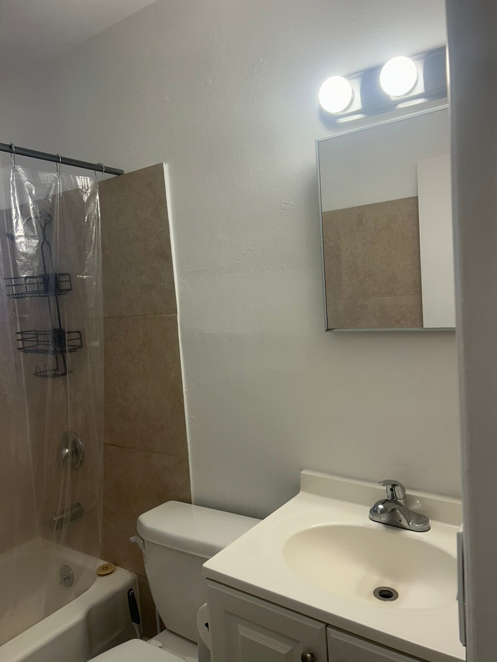 A white sink is on a white countertop in a bathroom.
