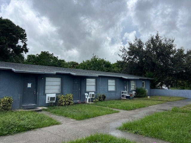 A grey house with a blue sky and clouds in the background.