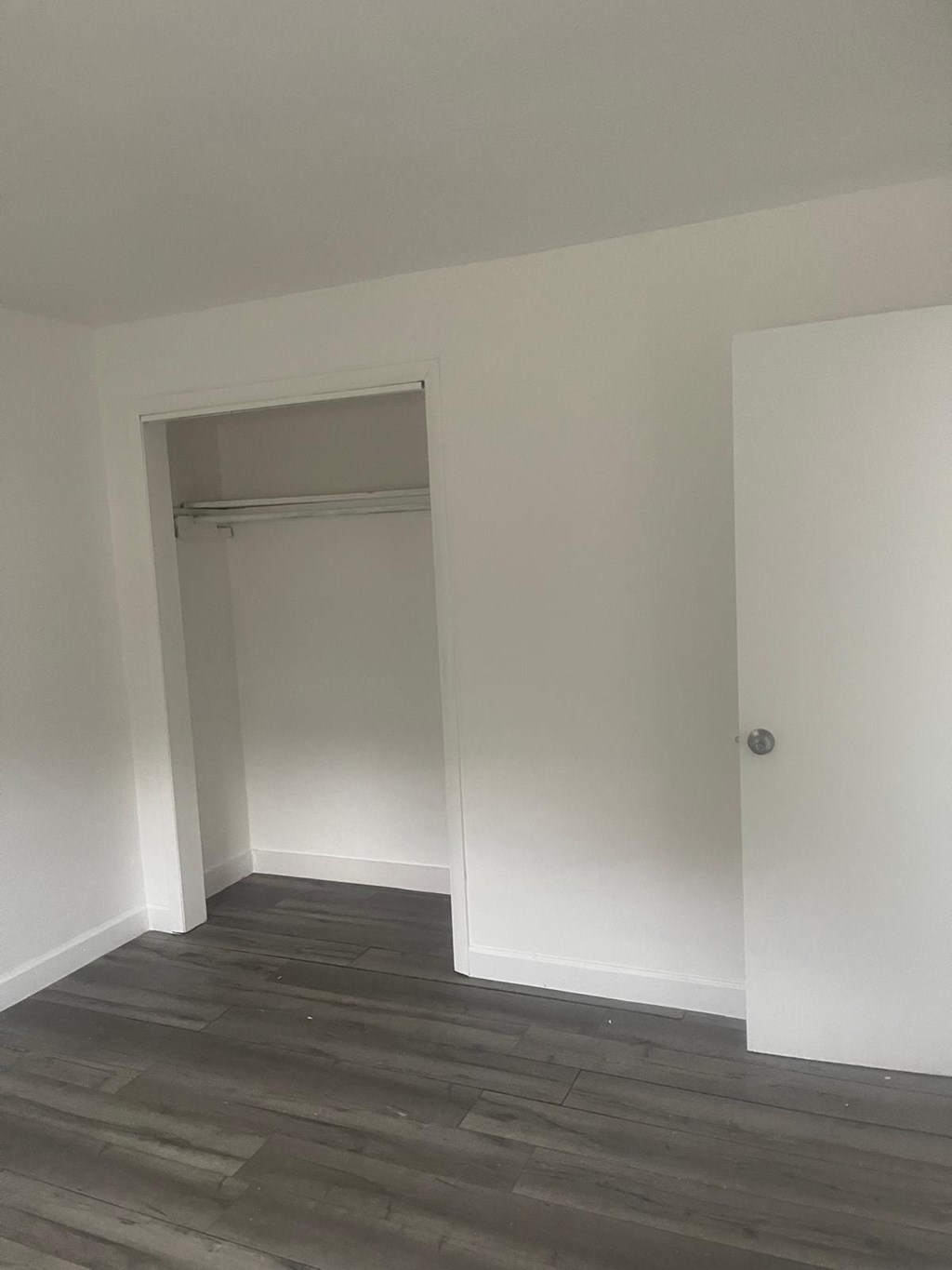 A room with a wooden floor and white walls.