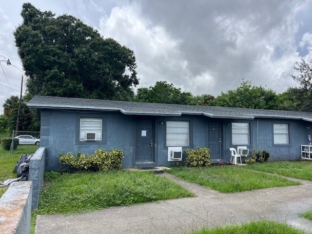A blue house with a grey roof and a grey car parked in front.