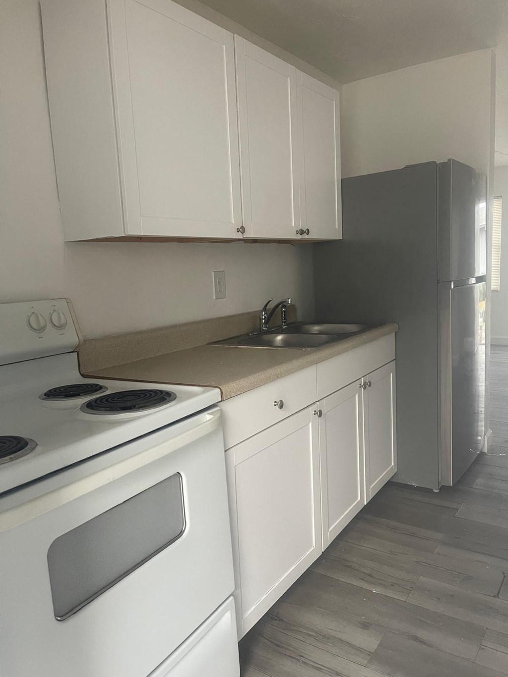 A kitchen with white cabinets and a white stove.