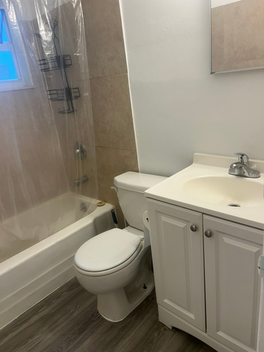 A white toilet sits next to a white sink in a bathroom.
