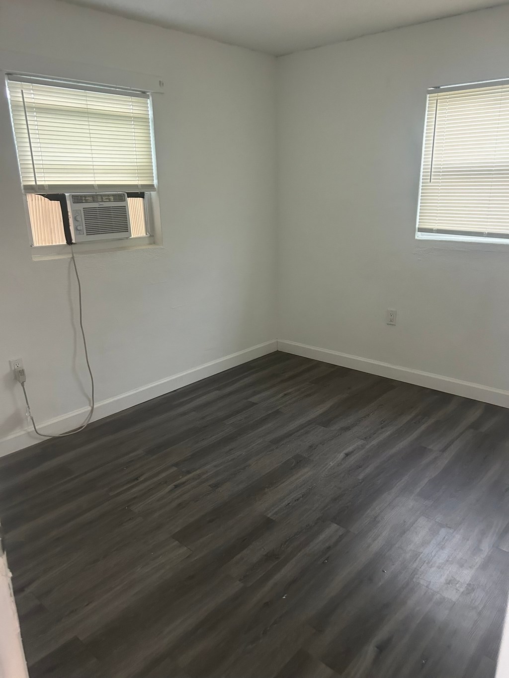 A room with a window and a wall-mounted air conditioner.