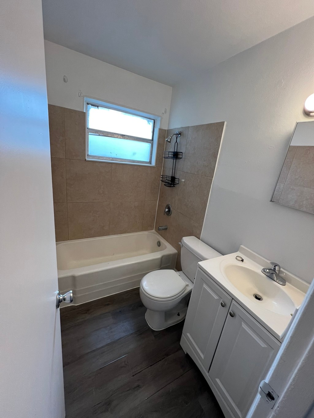 A bathroom with a toilet, sink, and tub.