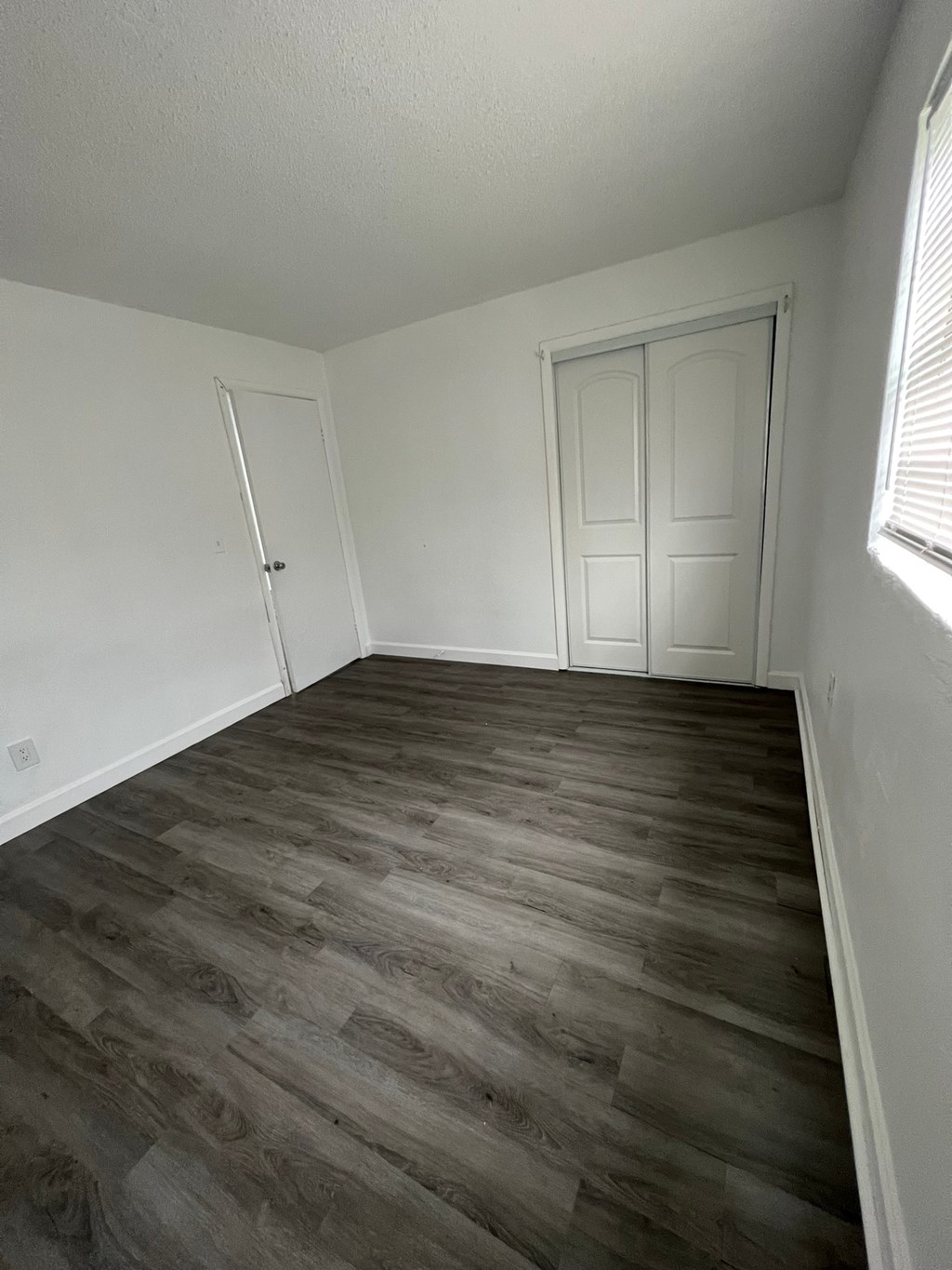 A room with a wooden floor and white walls.