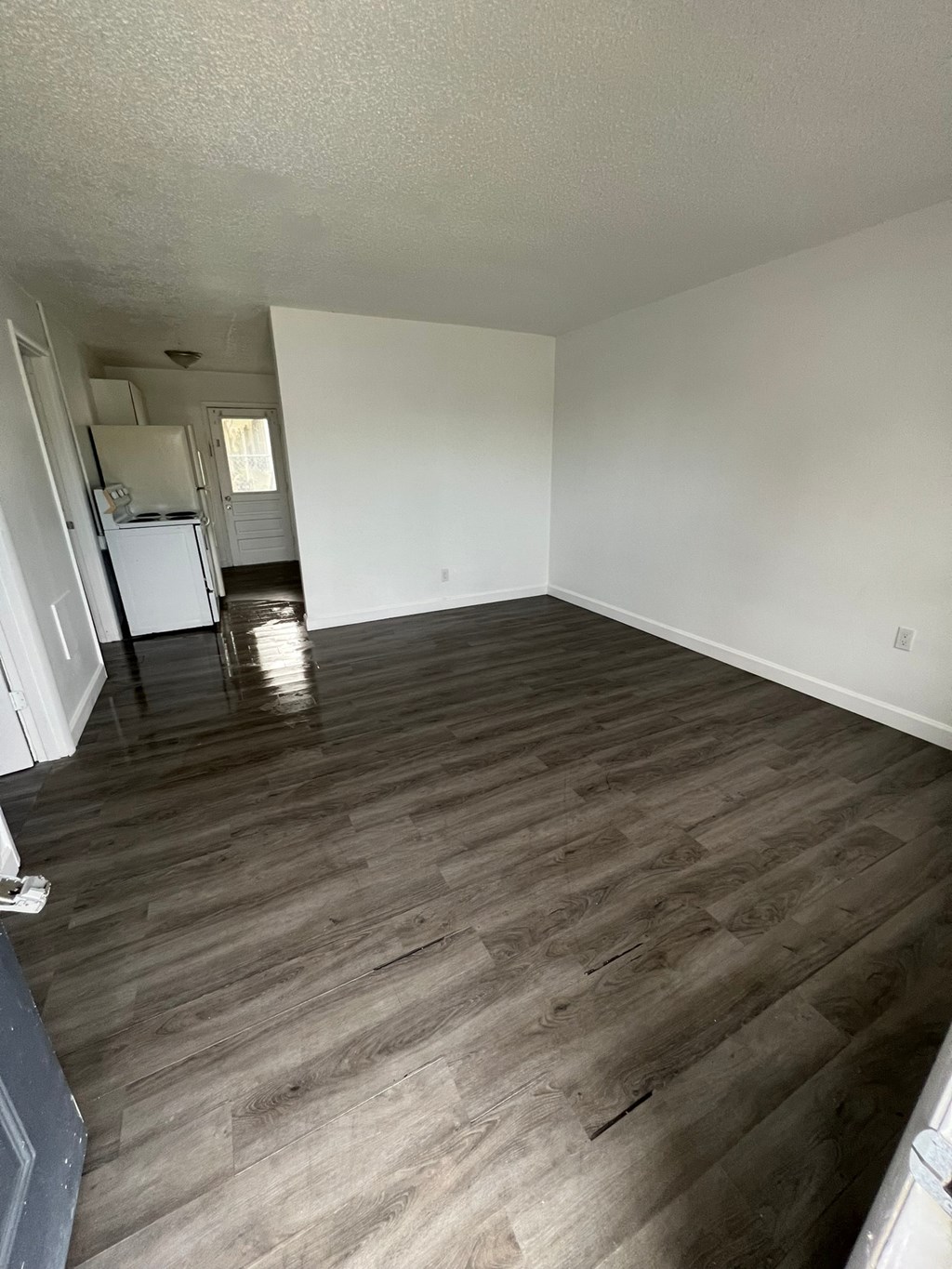 A room with wooden flooring and white walls.