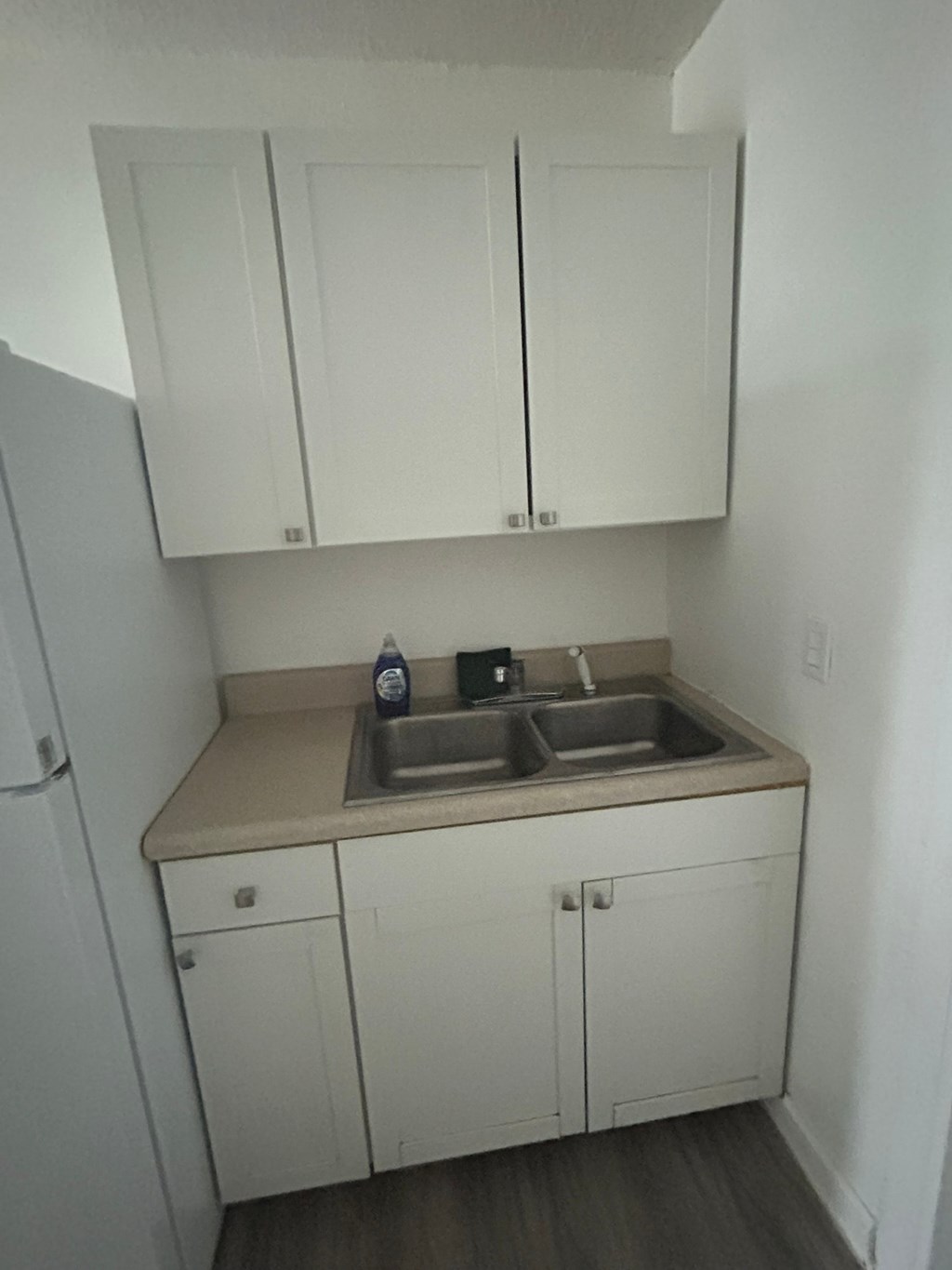 A kitchen with white cabinets and a beige countertop.