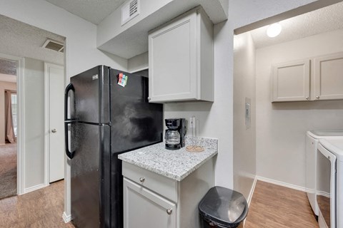 a kitchen with a refrigerator and a counter top with a coffee maker