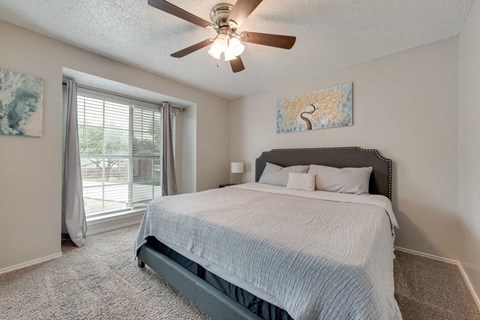 a bedroom with a bed and a ceiling fan
