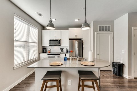 a kitchen with a large island with three stools